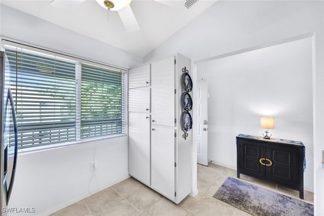 foyer featuring light tile patterned flooring, baseboards, visible vents, lofted ceiling, and a ceiling fan