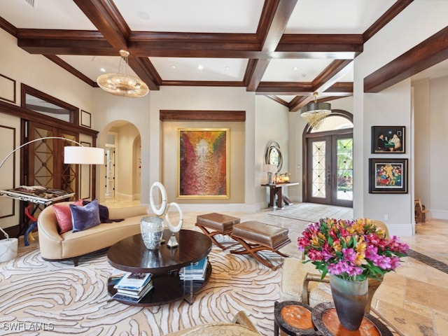 interior space featuring french doors, coffered ceiling, beam ceiling, ornamental molding, and a chandelier