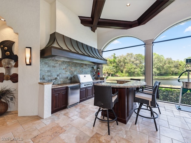 view of patio / terrace featuring a water view, an outdoor wet bar, an outdoor kitchen, and grilling area