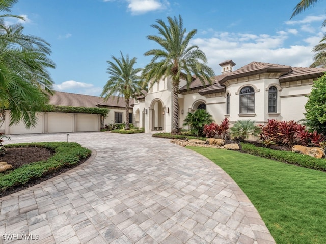 mediterranean / spanish-style house with a front lawn and a garage