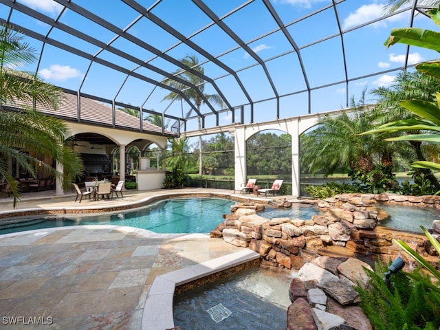 view of pool with a patio area, glass enclosure, and ceiling fan