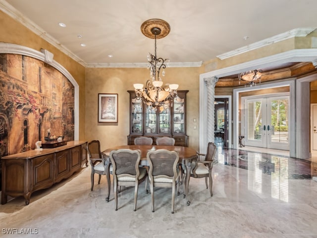 dining space with crown molding, french doors, and a chandelier