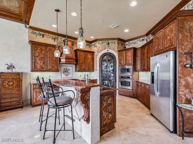 kitchen with an island with sink, crown molding, a kitchen bar, pendant lighting, and appliances with stainless steel finishes