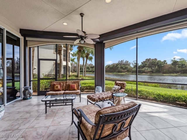 sunroom / solarium with a water view and ceiling fan