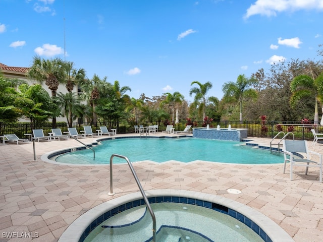 view of pool featuring a patio and a hot tub