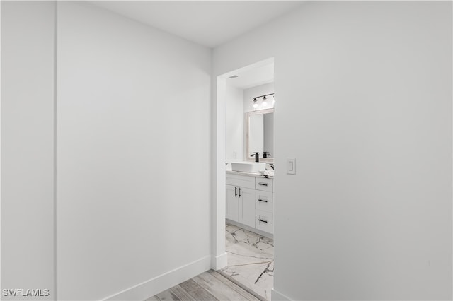 hallway featuring light wood-type flooring and sink