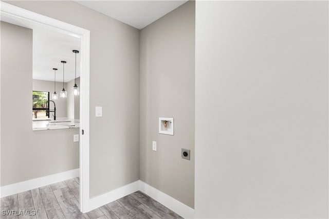 washroom featuring washer hookup, light hardwood / wood-style floors, and hookup for an electric dryer