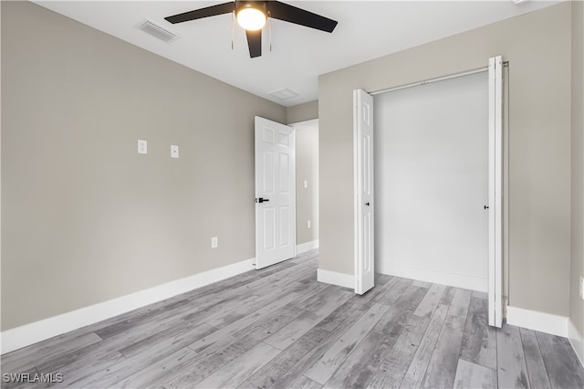 unfurnished bedroom with light hardwood / wood-style flooring, a closet, and ceiling fan