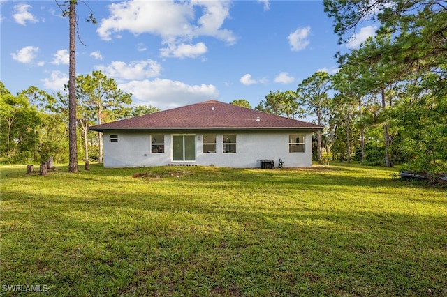 back of property featuring a yard and central AC