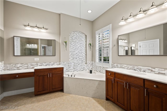 bathroom with backsplash, vanity, and a tub to relax in