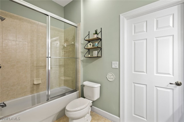 bathroom featuring toilet, combined bath / shower with glass door, and tile patterned floors