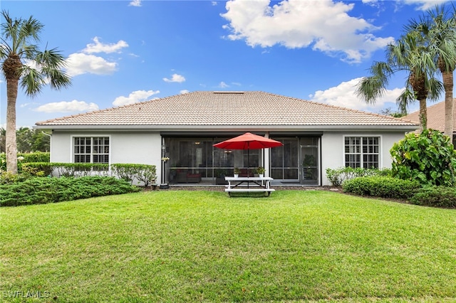 rear view of property featuring a yard and a sunroom