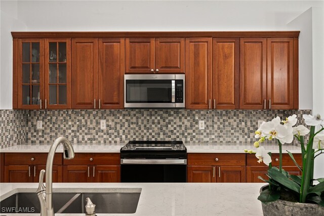 kitchen with tasteful backsplash, stainless steel appliances, and sink