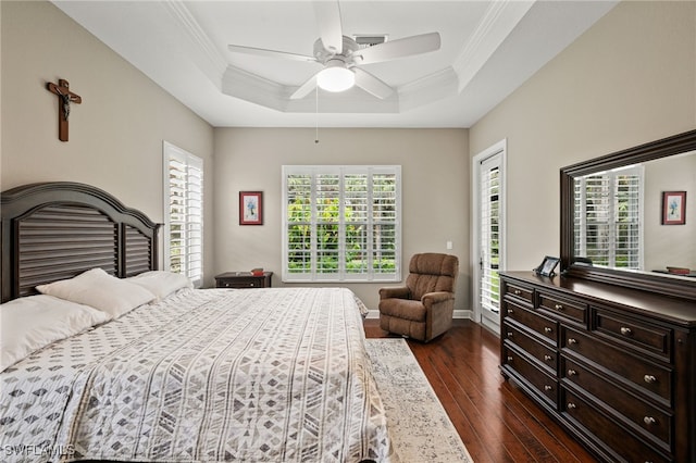 bedroom with ornamental molding, a raised ceiling, dark hardwood / wood-style floors, and ceiling fan