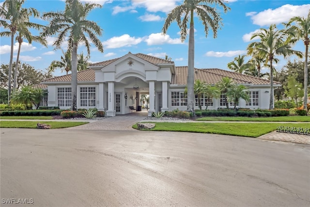 mediterranean / spanish home with a front lawn