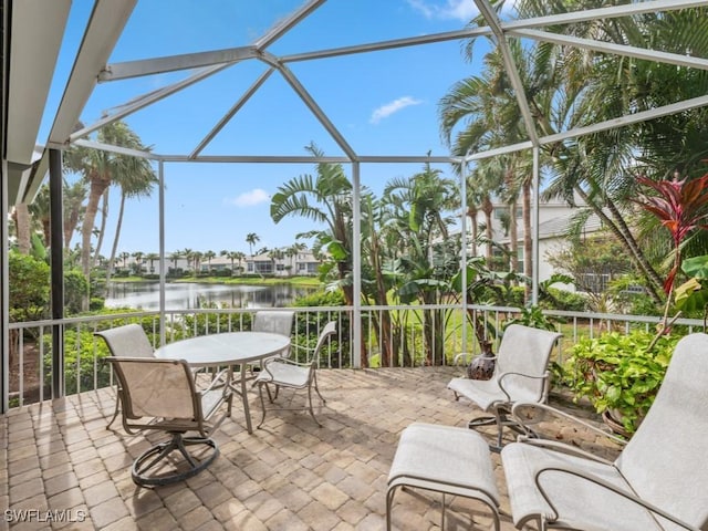 view of patio featuring a water view and a lanai