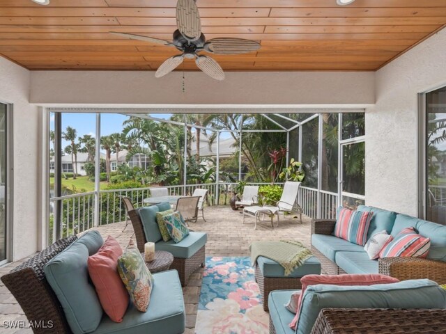 sunroom / solarium with ceiling fan, wood ceiling, and a wealth of natural light