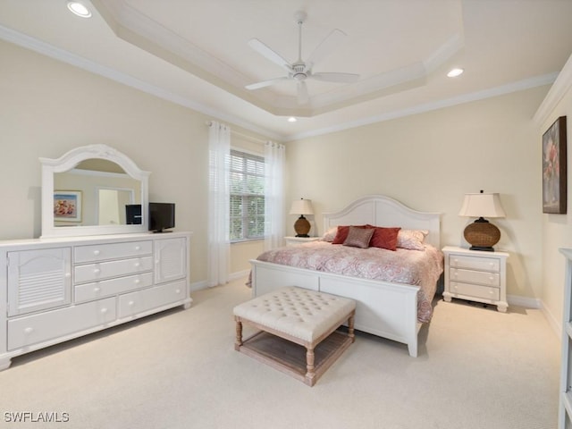 carpeted bedroom featuring ceiling fan, crown molding, and a tray ceiling