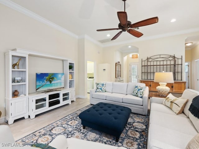 living room with light wood-type flooring, washer / clothes dryer, ceiling fan, and crown molding