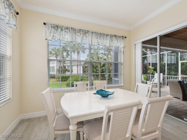 dining space with ornamental molding and light wood-type flooring