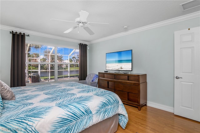 bedroom featuring light hardwood / wood-style floors, ceiling fan, and crown molding