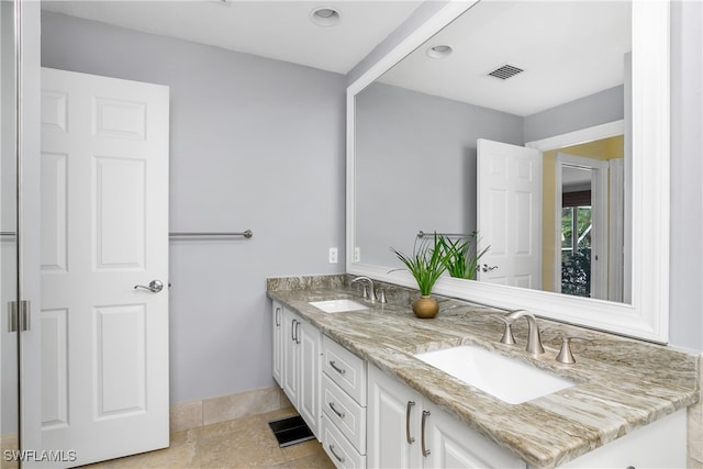 bathroom with visible vents, a sink, baseboards, and double vanity