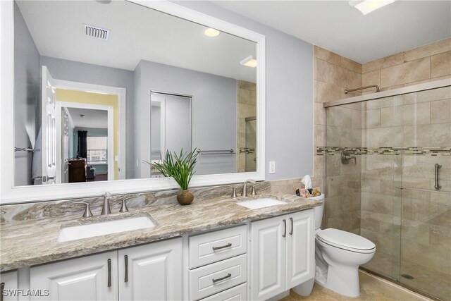 bathroom featuring a stall shower, a sink, and double vanity