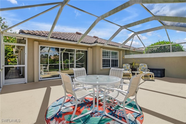 view of patio with outdoor dining space and a lanai