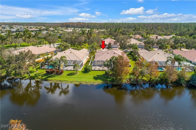 birds eye view of property with a water view, a residential view, and a wooded view