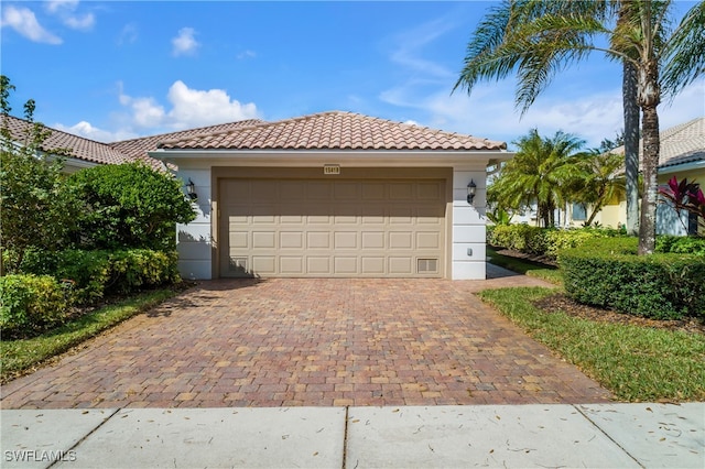 view of front facade with decorative driveway, a tile roof, and stucco siding