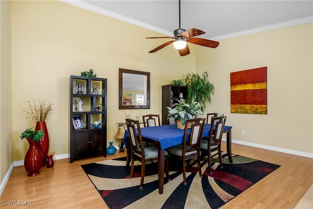 dining area featuring baseboards, wood finished floors, a ceiling fan, and crown molding