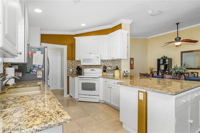 kitchen with a peninsula, white appliances, white cabinetry, and a sink