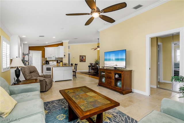 living room featuring ceiling fan, light tile patterned floors, and crown molding