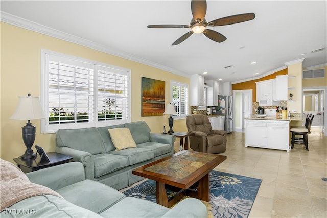 living room featuring ceiling fan, visible vents, vaulted ceiling, and crown molding