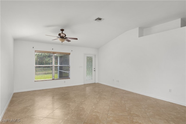 empty room featuring lofted ceiling, light tile patterned floors, and ceiling fan