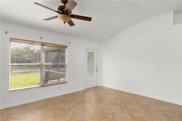 tiled spare room with ceiling fan and vaulted ceiling