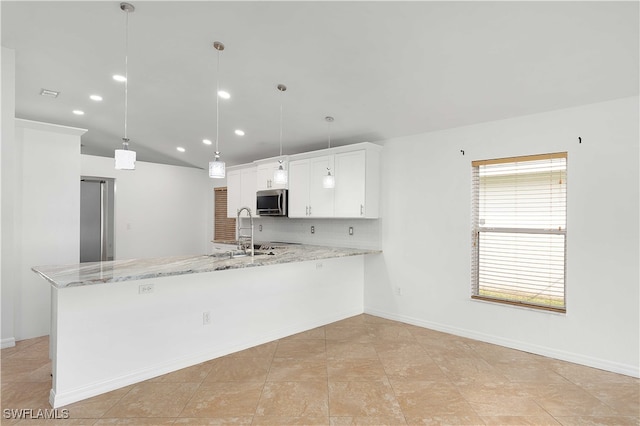 kitchen with sink, decorative light fixtures, white cabinets, light stone counters, and decorative backsplash