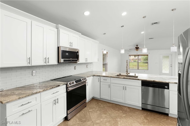 kitchen featuring kitchen peninsula, appliances with stainless steel finishes, sink, and pendant lighting