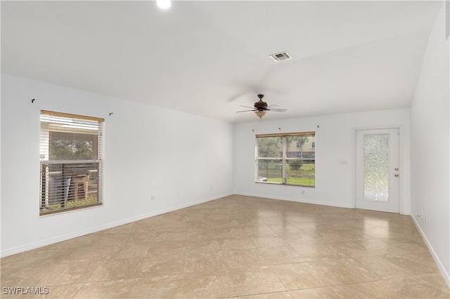 unfurnished room with a healthy amount of sunlight, vaulted ceiling, and ceiling fan