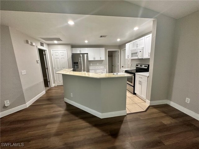 2611 4th St SW, Lehigh Acres, FL 33976 - kitchen featuring appliances with stainless steel finishes, white cabinetry, wood finished floors, and recessed lighting