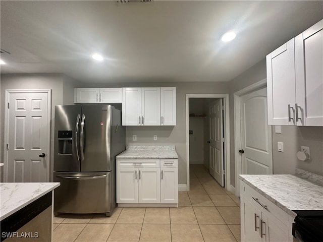 kitchen featuring white cabinets, stainless steel refrigerator with ice dispenser, and light stone countertops