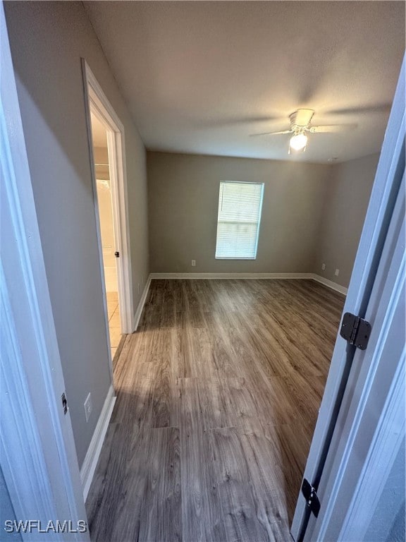 empty room featuring ceiling fan and dark hardwood / wood-style flooring