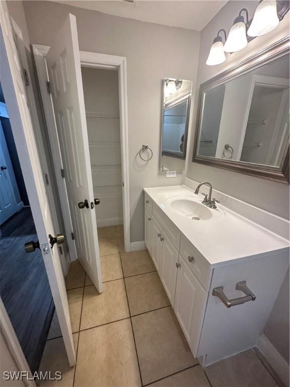 2611 4th St SW, Lehigh Acres, FL 33976 - bathroom with vanity, tile patterned flooring, baseboards, and a spacious closet