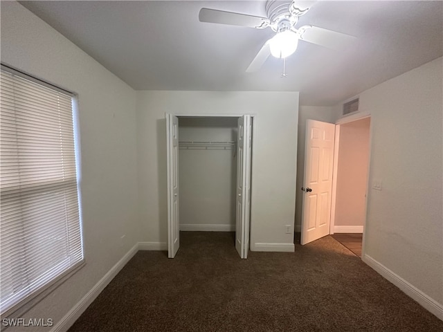 unfurnished bedroom featuring dark carpet, ceiling fan, and a closet