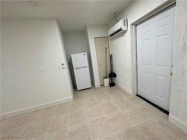 laundry area featuring a barn door, light tile patterned floors, and a wall mounted AC