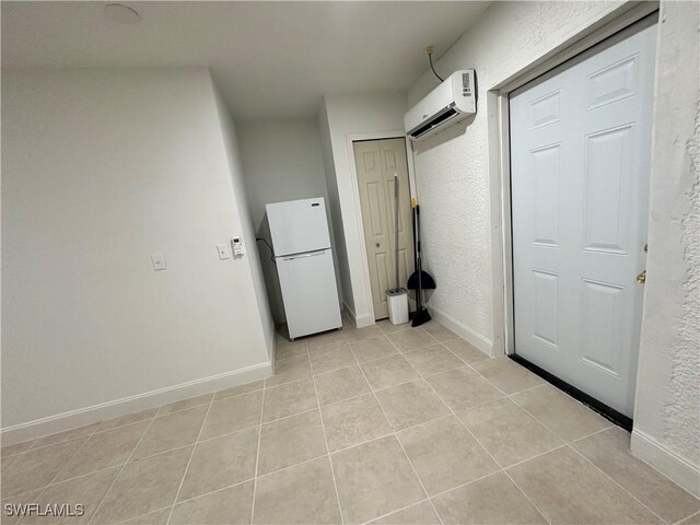 2611 4th St SW, Lehigh Acres, FL 33976 - washroom with a wall unit AC, light tile patterned floors, baseboards, and a textured wall