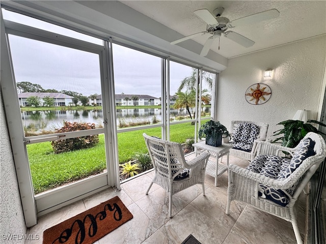 sunroom with a water view and ceiling fan