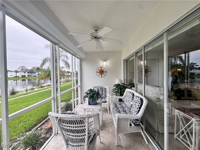 sunroom with a water view and ceiling fan