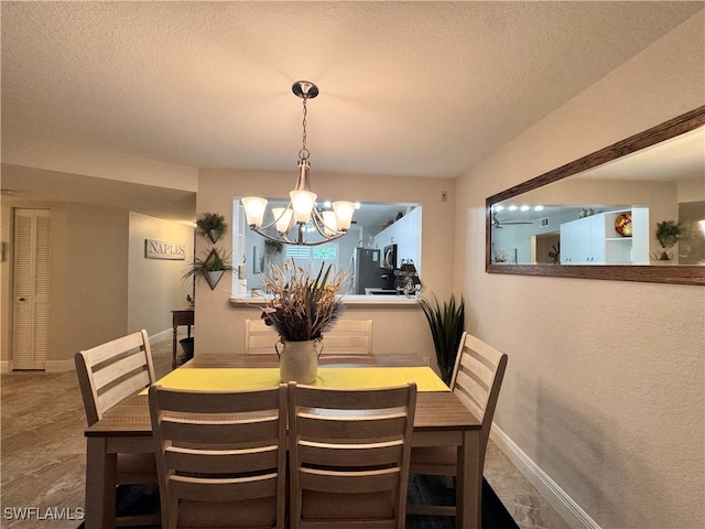 dining room featuring a notable chandelier and a textured ceiling