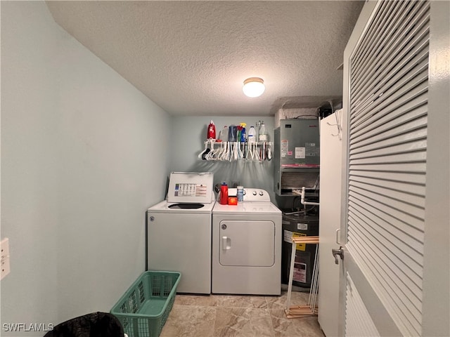 laundry area with washer and clothes dryer and a textured ceiling